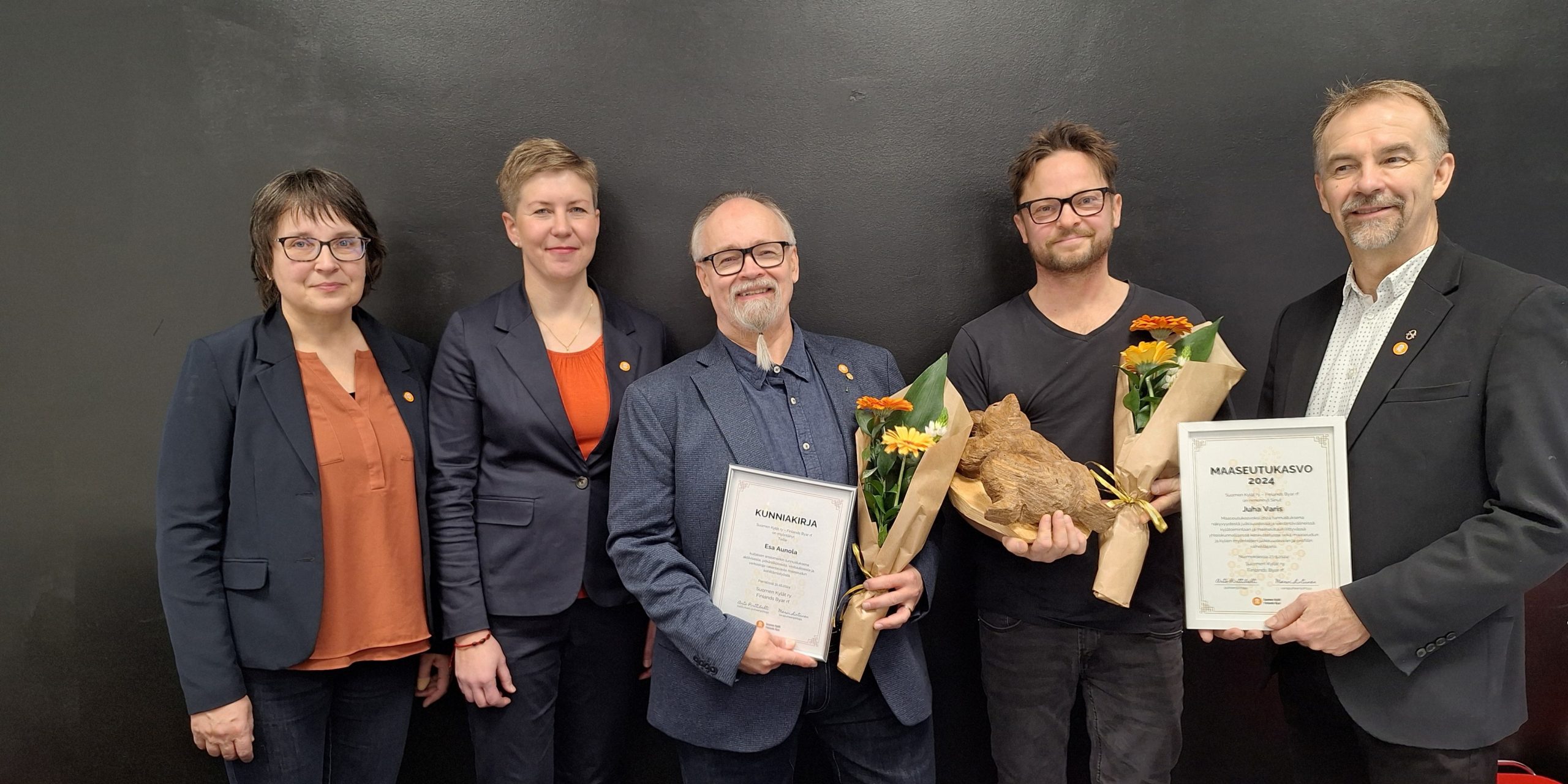 2. Kuvassa kaikki palkitut, sekä myöntäjät vasemmalta oikealle: Suomen kylien 2. varapuheenjohtaja Maarit Teuri, Suomen kylien toiminnanjohtaja Suvi Louhelainen, kultainen ansiomerkki Esa Aunola, Vuoden maaseutukasvo Juha Varis, Suomen kylien hallituksen puheenjohtaja Arto Pirttilahti