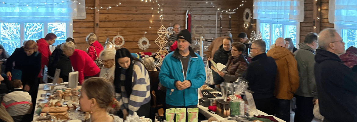 Korpilahden Moksin avoimet joulukylät. Ihmisiä pirtissä katsomassa markkinoita.